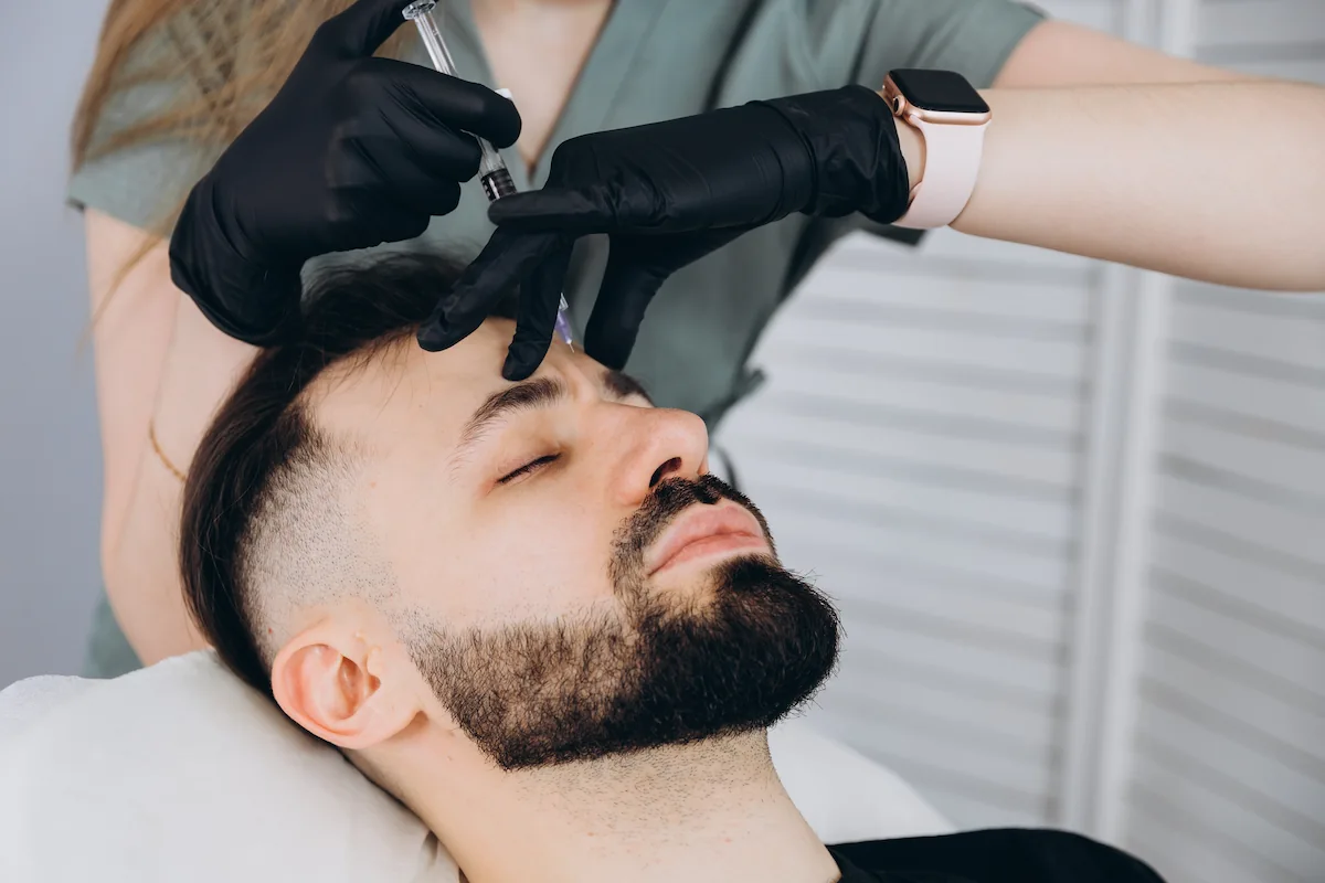 Man receiving a BOTOX injection in his forehead